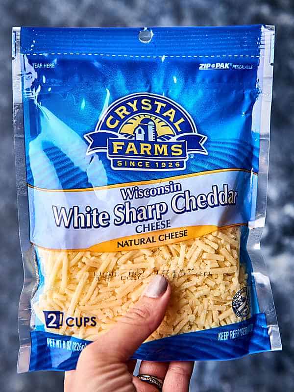 bag of Crystal Farms white sharp cheddar cheese held