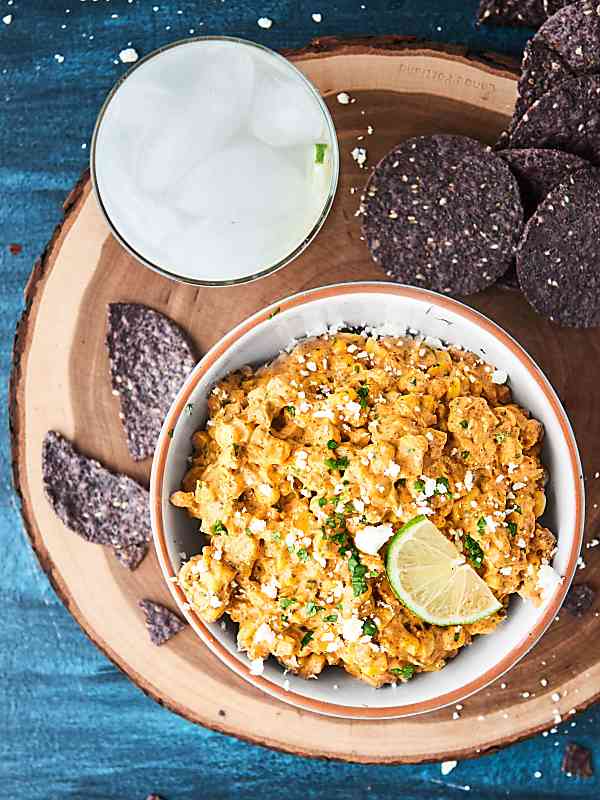 mexican corn dip in bowl next to tortilla chips above