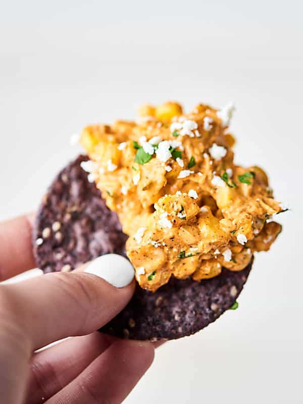 tortilla chip with mexican corn dip held