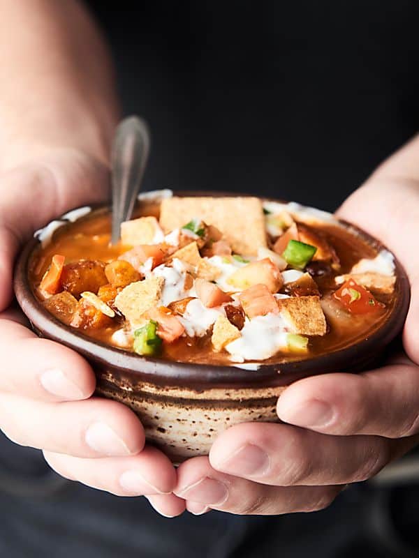 Bowl of vegetarian chili held in two hands