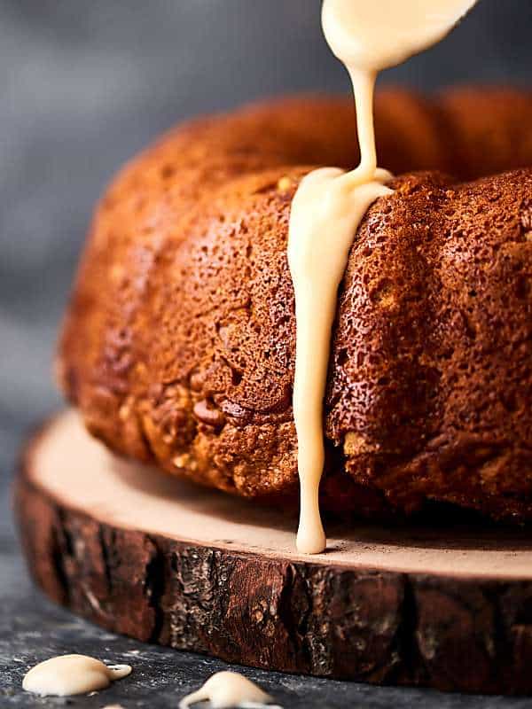 icing being drizzled over pumpkin coffee cake