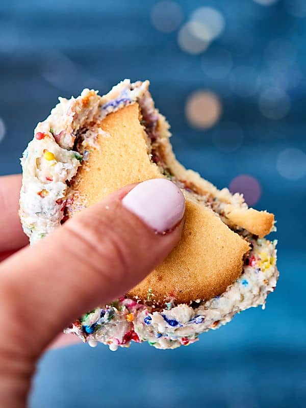 Nilla wafers sandwiching cake batter dip held