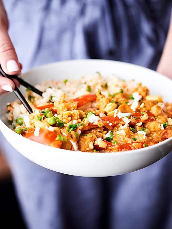 Bowl of slow cooker vegetable curry held with chopsticks