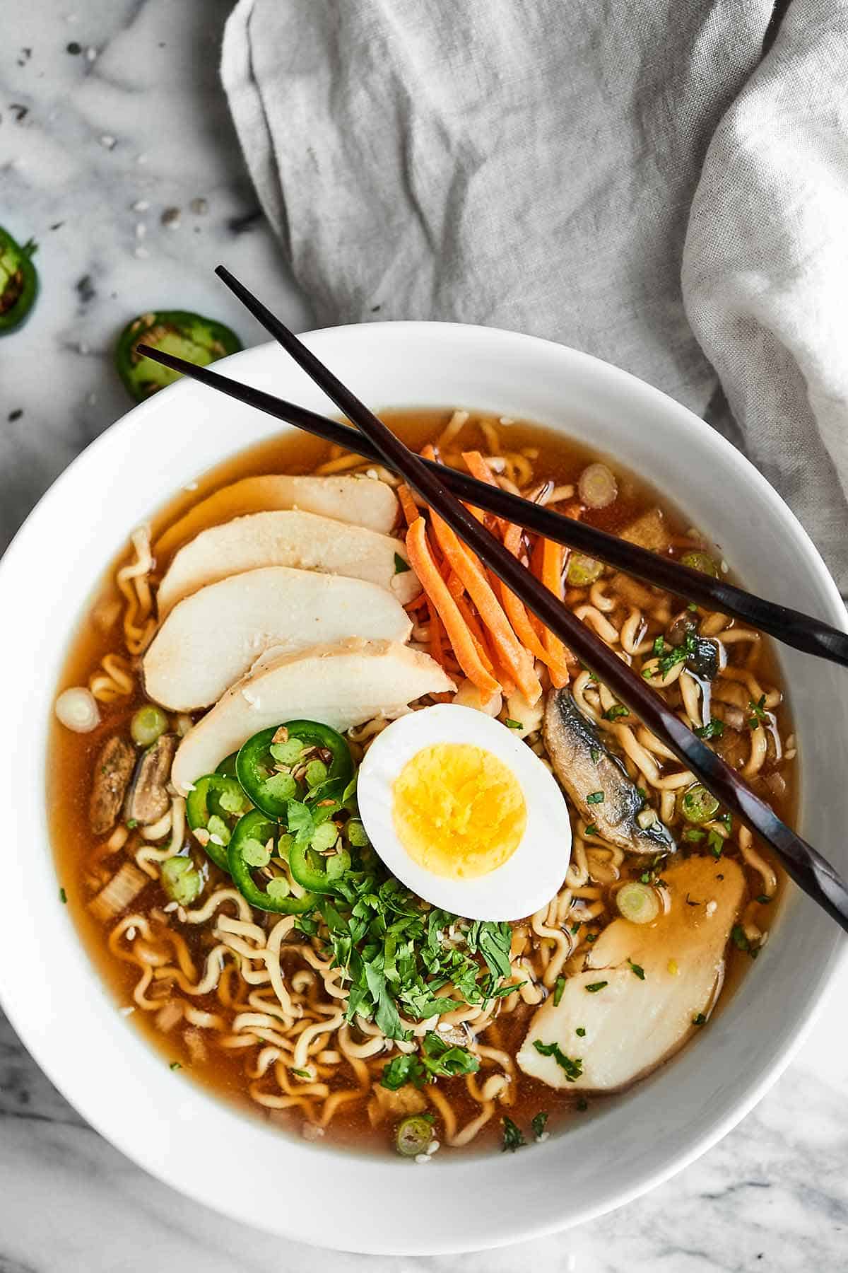 Slower cooker ramen in a bowl with chopsticks above