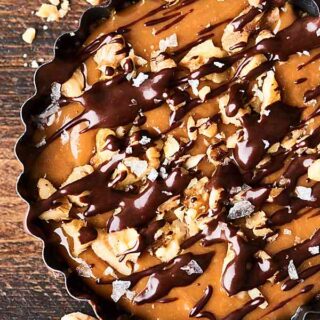 #ad These No-Bake Easy Caramel Walnut Tarts are mind blowing delicious. Walnut, graham cracker crust topped with a two ingredient caramel, more walnuts, a two ingredient chocolate ganache and sea salt! showmetheyummy.com Made in partnership w/ @CAWalnuts