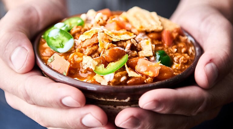 Bowl of chili held in two hands