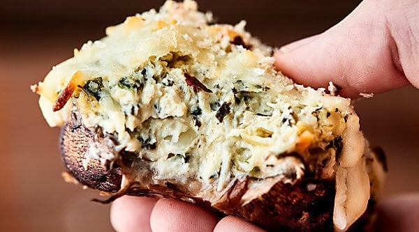 #ad Healthier Spinach Artichoke Stuffed Mushrooms, the perfect appetizer for easy entertaining! Mushroom caps stuffed with a greek yogurt spinach artichoke dip, topped with mozzarella, and baked to gooey perfection! showmetheyummy.com Made in partnership w/ @laterrafina