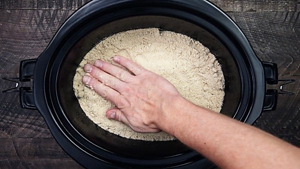 cake mix being pressed into crockpot