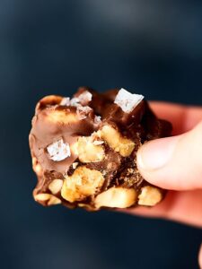 These Easy Peanut Clusters only require four ingredients: vanilla almond bark, chocolate chips, peanuts, and sea salt! showmetheyummy.com