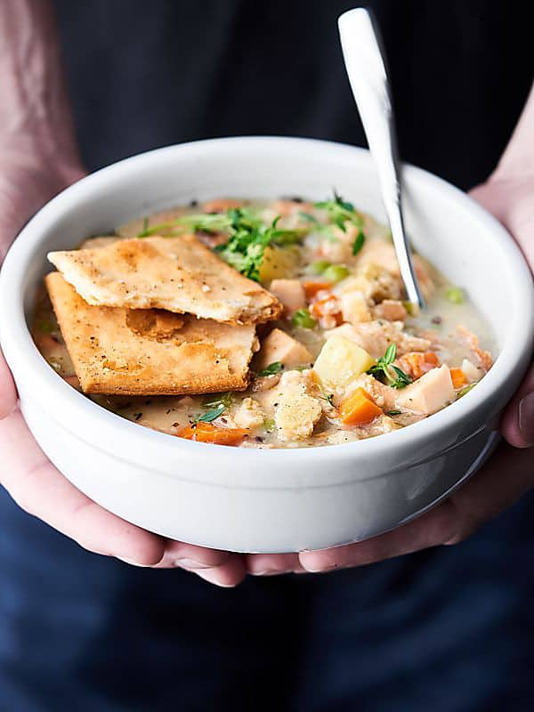 bowl of healthy turkey pot pie soup held two hands