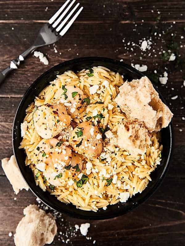 lemon pepper scallops with orzo pasta in skillet above