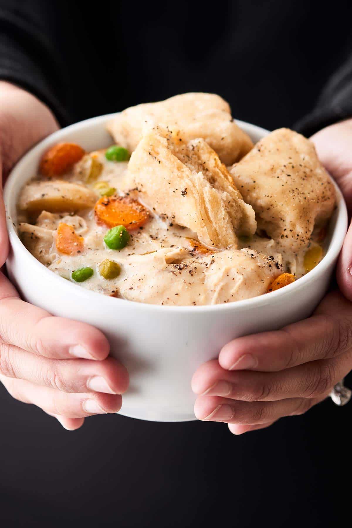 Bowl of crock pot chicken and dumplings held