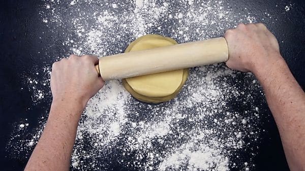 dough ball being rolled with rolling pin