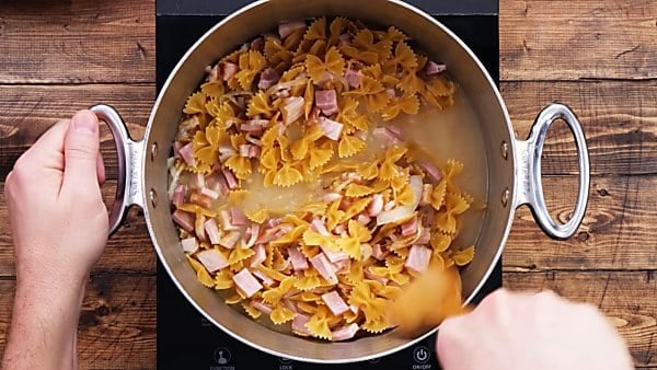 pasta and ham added to stockpot with broth