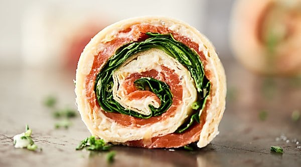 #ad These Smoked Salmon Pinwheels are perfect for easy and elegant holiday entertaining. Quick and easy to make with only four ingredients: tortillas, a lemon pepper and asiago spread, smoked salmon, and spinach! showmetheyummy.com Made in partnership w/ @laterrafina