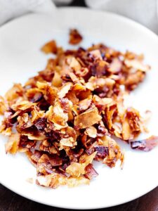 Easy Coconut Bacon. A vegan alternative to "real bacon"! Made with coconut, soy sauce, liquid smoke, and maple syrup! Gluten free! Ready in 15 minutes! showmetheyummy.com #vegan #coconutbacon