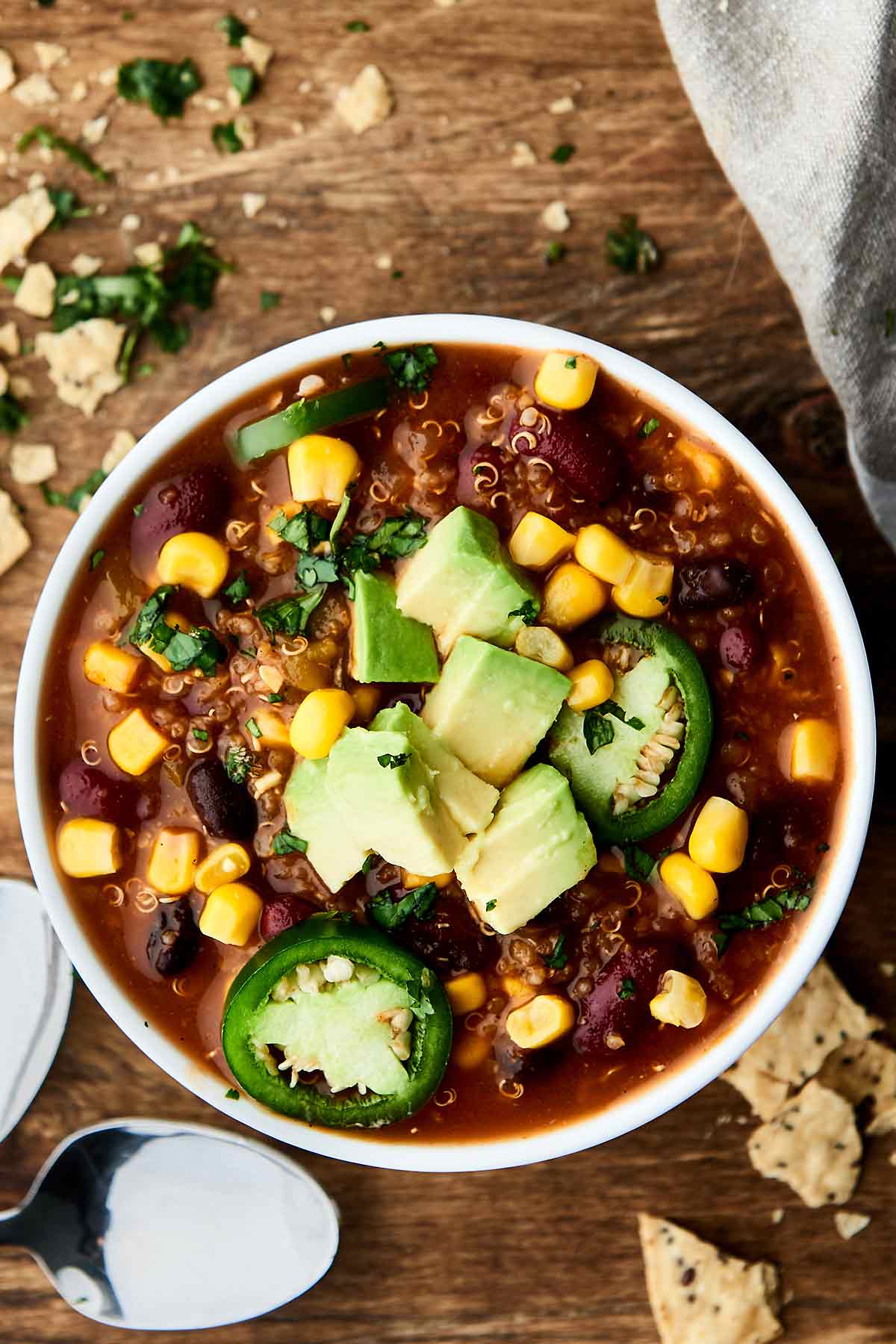 Instant pot vegetarian chili in a bowl with avocado and jalapeño slices above