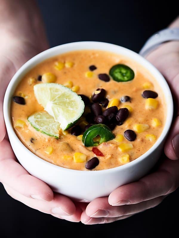 bowl of loaded queso held two hands