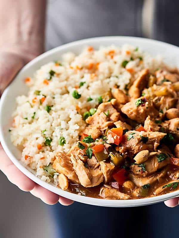 Plate of slow cooker kung pao chicken with rice held