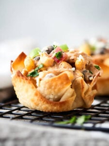 Southwestern chicken salad cups. Baked wonton cups filled with chicken, corn, beans, peppers, greek yogurt, lime, and taco seasonings! About 100 calories per cup! Great for easy lunches, snacks, or a big party! showmetheyummy.com #wonton #chickensalad