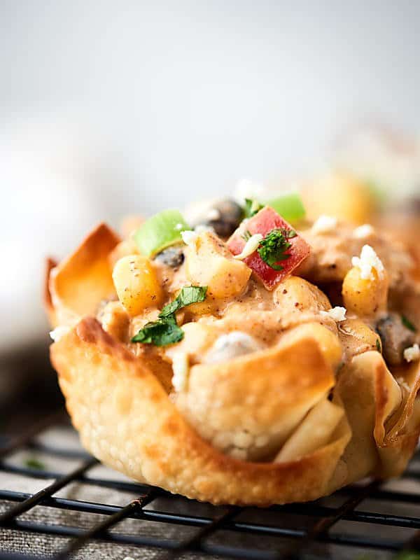 Southwestern chicken salad cups. Baked wonton cups filled with chicken, corn, beans, peppers, greek yogurt, lime, and taco seasonings! About 100 calories per cup! Great for easy lunches, snacks, or a big party! showmetheyummy.com #wonton #chickensalad