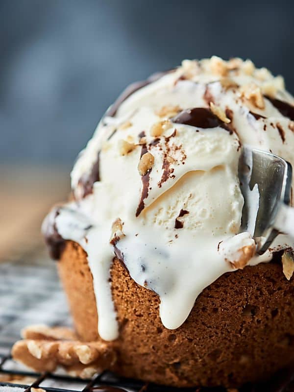 fork cutting into deep dish walnut chocolate chip cookie with ice cream