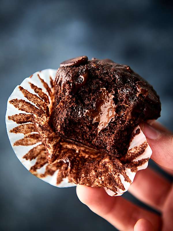 Chocolate muffin with bite out held