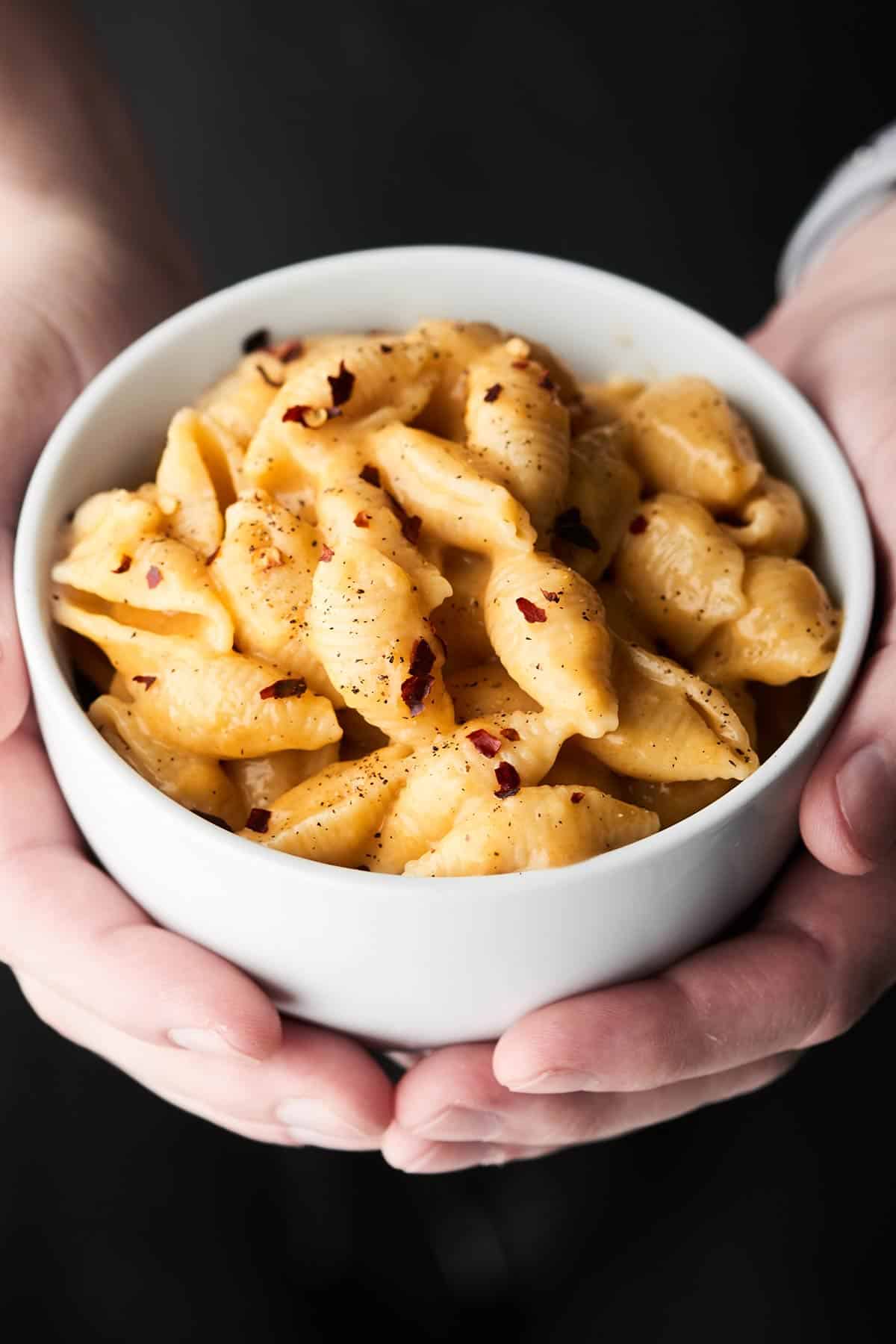 bowl of instant pot mac and cheese held two hands