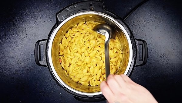 finished instant pot mac and cheese being scooped with ladle