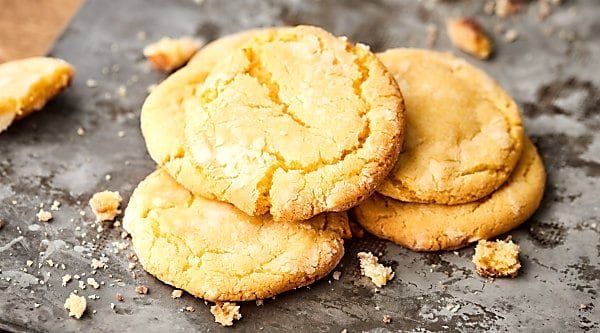 en fjäder twist på en choklad klassiker, dessa citron crinkle cookies är ljusa, citron-y, och helt söt! Min hemliga ingrediens? Citronpuddingblandning och vit choklad! showmetheyummy.com # citron # kakor
