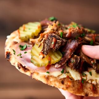 #ad This mini cuban naan pizzas might just be the easiest dinner yet! Slow cooker pork paired with ham, naan bread, swiss cheese, mustard, and pickles! 15 minute dinner. showmetheyummy.com Made in partnership w/ @smithfieldfoods #RealFlavorRealFast #pizza