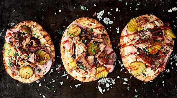 #ad This mini cuban naan pizzas might just be the easiest dinner yet! Slow cooker pork paired with ham, naan bread, swiss cheese, mustard, and pickles! 15 minute dinner. showmetheyummy.com Made in partnership w/ @smithfieldfoods #RealFlavorRealFast #pizza