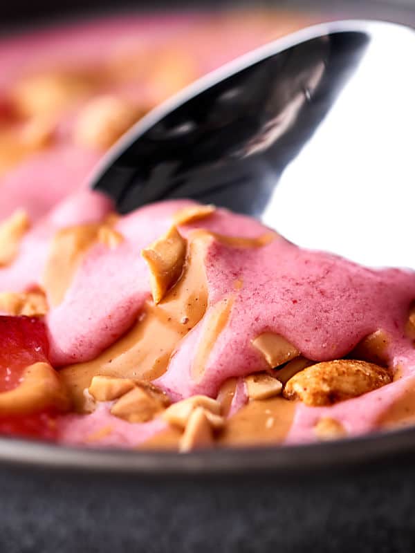 A favorite sandwich from your childhood turned into a healthy smoothie bowl: these peanut butter and jelly smoothie bowls are absolutely delicious! Full of frozen strawberries and all natural peanut butter, they really do taste like the childhood classic! showmetheyummy.com #smoothie #peanutbutter #jelly