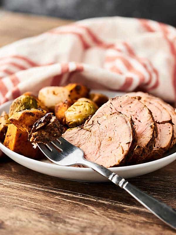This Pork Tenderloin Recipe is quick, easy, healthy, and so tasty! Loaded with pork, sweet potatoes, brussels sprouts, onion, and apples, and smothered in balsamic vinegar and spices: garlic, rosemary, thyme, paprika, salt, and pepper! showmetheyummy.com #sheetpandinner #pork