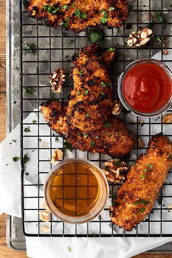 sweet spicy walnut chicken tenders on cooling rack above