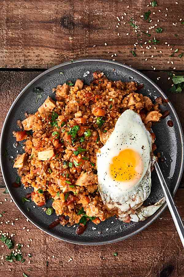 chicken cauliflower fried rice with fried egg on plate above