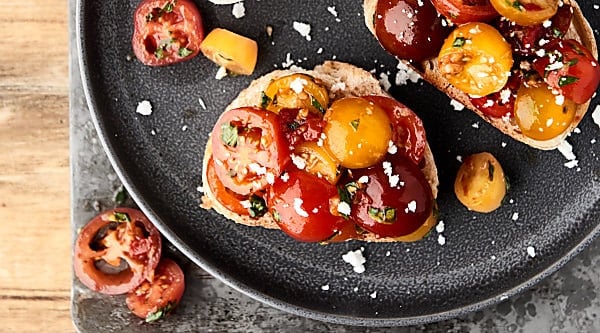 This easy bruschetta recipe is a healthy summer classic! Juicy tomatoes tossed with sun dried tomatoes, garlic, a touch of oil, balsamic vinegar, and fresh basil . . . we can't get enough of this stuff! showmetheyummy.com #bruschetta #summerrecipe #healthy #vegan