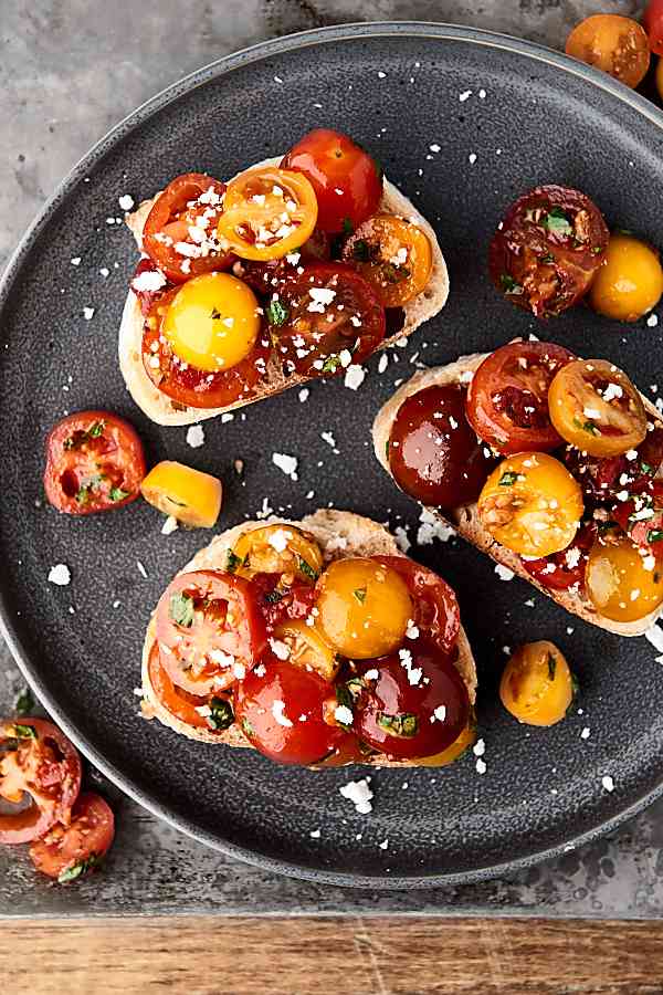 This easy bruschetta recipe is a healthy summer classic! Juicy tomatoes tossed with sun dried tomatoes, garlic, a touch of oil, balsamic vinegar, and fresh basil . . . we can't get enough of this stuff! showmetheyummy.com #bruschetta #summerrecipe #healthy #vegan