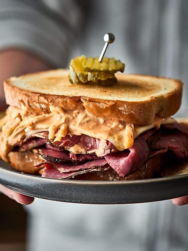 Pastrami sandwich on a plate held