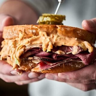 #ad A twist on a classic, this pastrami sandwich is outta this world good! Artisan-style bread loaded with thinly sliced pastrami, swiss cheese, and the BEST coleslaw made with a tangy homemade russian dressing. Can be served hot or cold! showmetheyummy.com Made in partnership w/ @SaraLeeBread #saraleebread #artesanobread