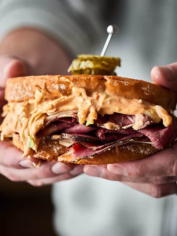 Pastrami sandwich held in two hands