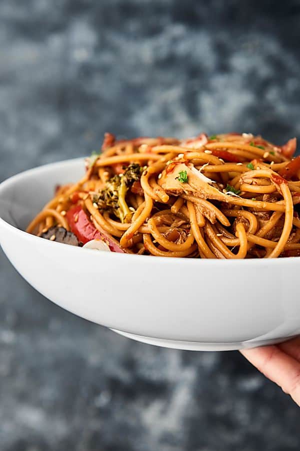 Slow cooker lo mein in a bowl held 