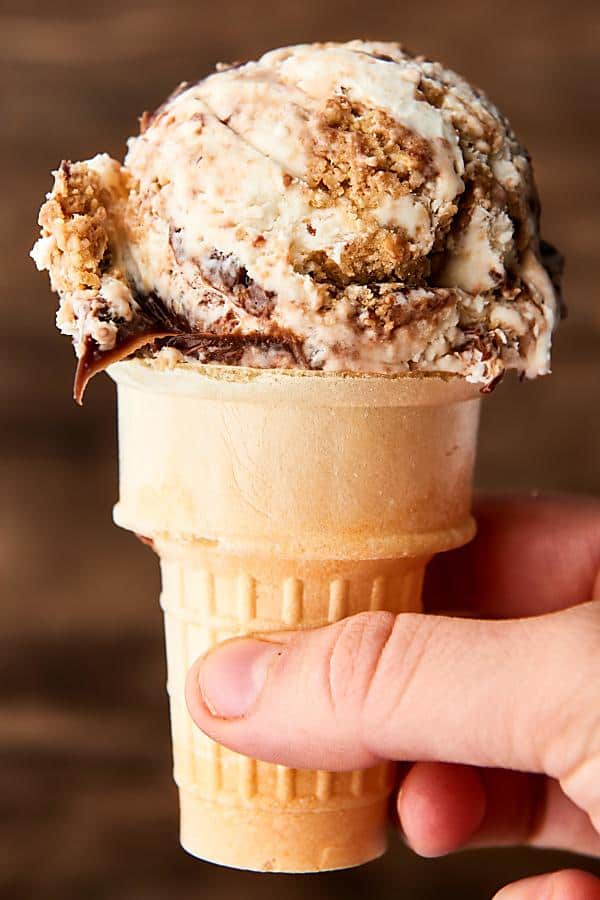 chocolate chip cookie dough ice cream in cake cone held