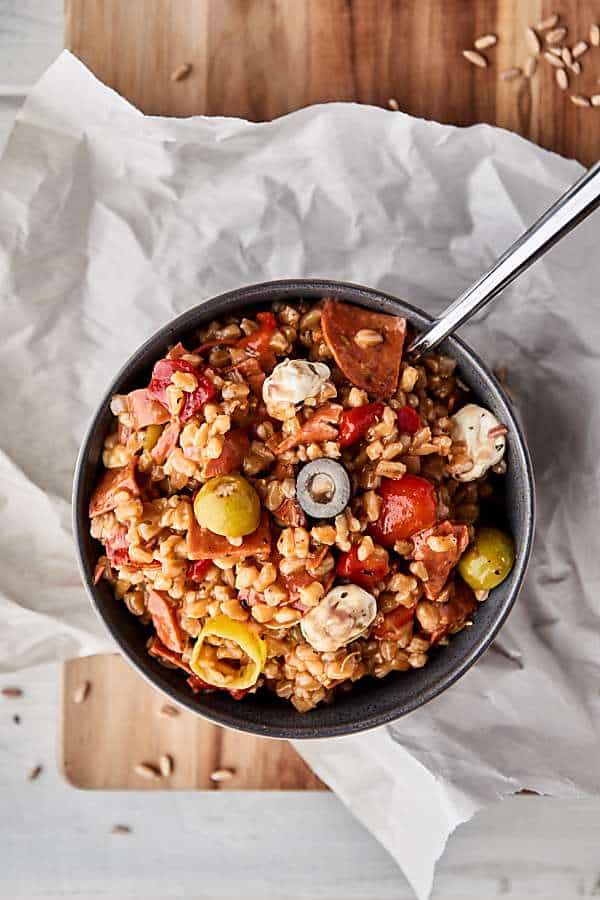 #ad This Antipasto Farro Salad is loaded with farro and all your favorite antipasto ingredients: roasted red pepper, tomatoes, onion, pepperoni, salami, mozzarella, pepperoncinis, olives, and more! Light yet SO satisfying. showmetheyummy.com Made in partnership w/ @bobsredmill #farro #antipasto #salad