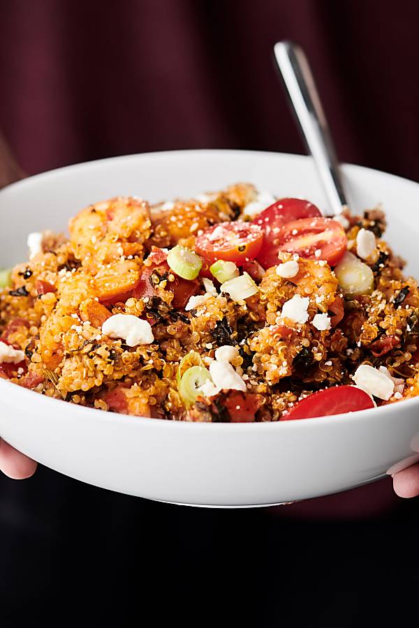 bowl of spanish shrimp and quinoa held two hands