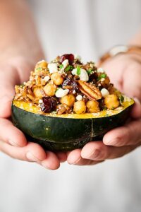 Instant Pot Stuffed Acorn Squash. Squash stuffed with veggies, wild rice, spices, herbs, chickpeas, cranberries, pecans, and more! Perfect for an easy meatless weeknight meal or as a vegetarian/vegan Thanksgiving side or main! Easy, healthy, can be vegan and gluten free! showmetheyummy.com #vegan #thanksgiving #instantpot #stuffedacornsquash #wildrice