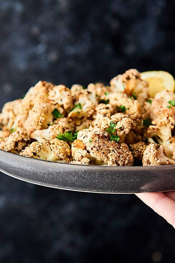 Mediterranean roasted cauliflower on a plate held