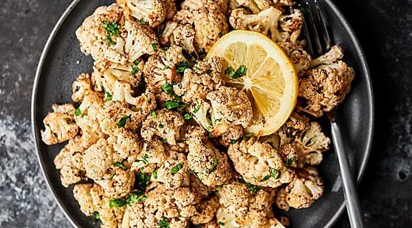 This Mediterranean Roasted Cauliflower Recipe is healthy, gluten free, can be vegan, and is absolutely delicious! Marinated in lemon juice, balsamic vinegar, and spices: salt, basil, garlic powder, onion powder, pepper, oregano, and thyme all day and roasted to perfection. Quick and easy vegetable side dish! showmetheyummy.com #mediterranean #roastedcauliflower