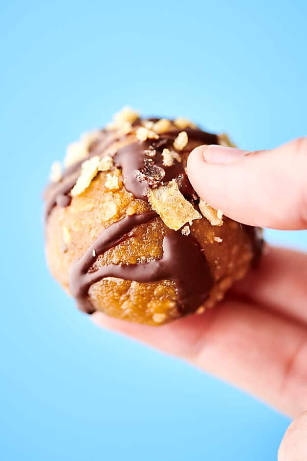 sweet and salty potato chip truffle held blue background