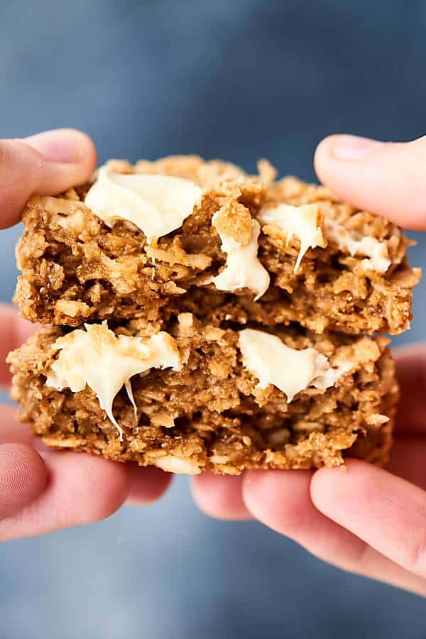 two halves coconut oatmeal cookie stacked held
